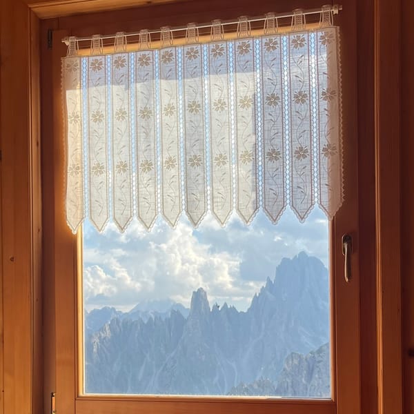 The Dolomites through the window of a wood-panelled room